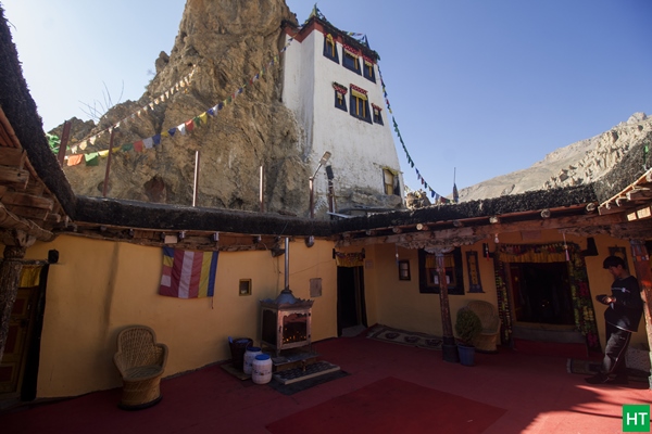 Inside Dhankar Monastery’s cliffside courtyard with prayer flags and old mud walls — a must‑visit in Spiti