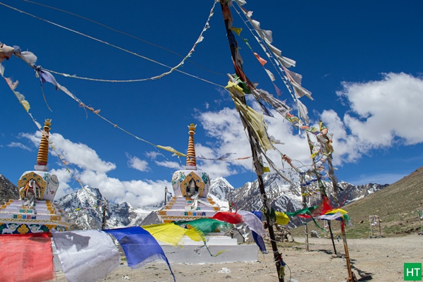 Prayer flags and chortens at Kunzum La (~4,551 m), the seasonal Manali–Spiti gateway, usually open late May/June to October