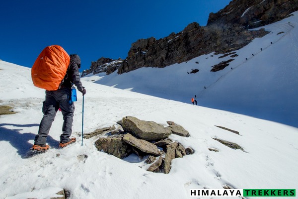 Beginner trekker using microspikes on compacted snow, Indian Himalaya winter trail
